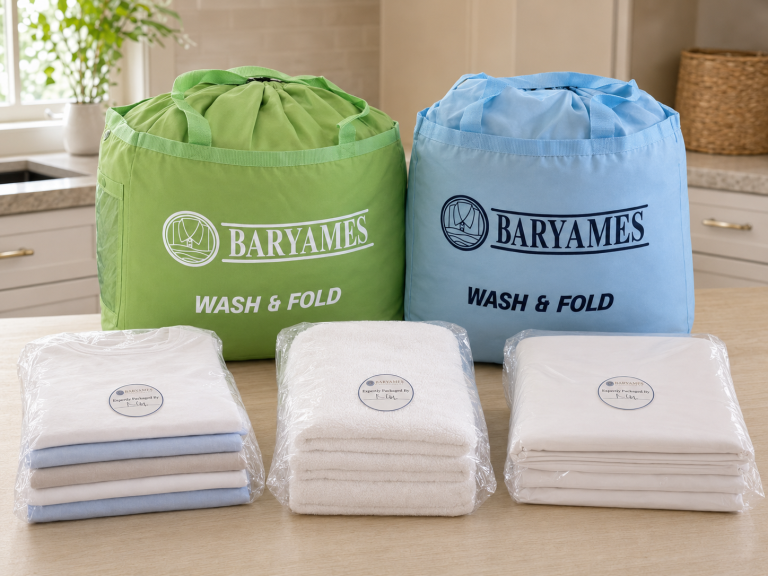 Green and blue Baryames Wash and Fold bags with professionally folded and wrapped shirts, towels, and sheets